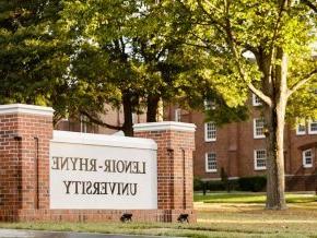 View of entrance to campus 和 university sign 